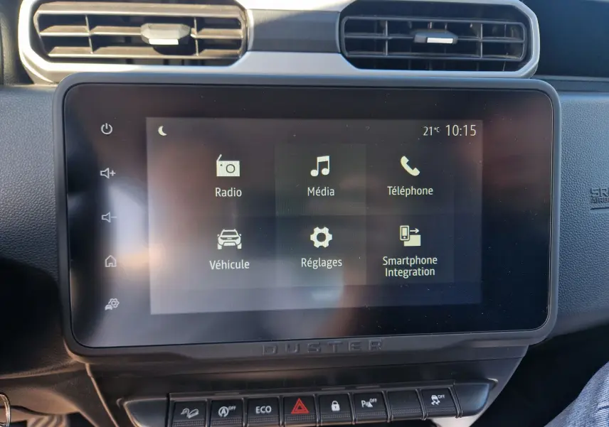 Vue rapprochée de l’écran tactile central du Dacia Duster 2024 avec interface multimédia et commandes sous l’écran.