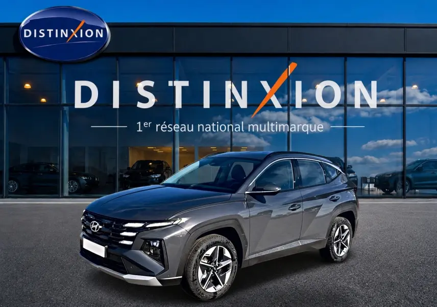 Hyundai Tucson gris ecotronic en 3/4 avant droit, avec jantes alu 18 pouces et calandre distinctive.