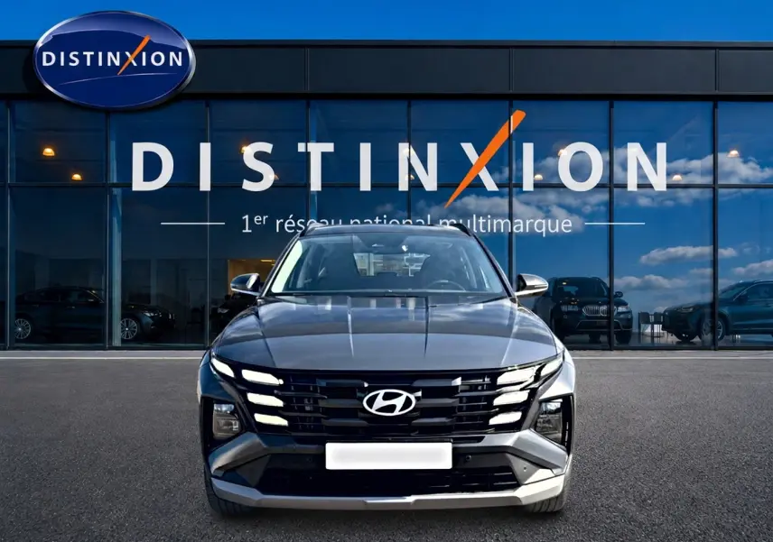 Vue avant d'un Hyundai Tucson 1.6 t-gdi 239 hybride gris ecotronic avec calandre noire et phares LED intégrés.
