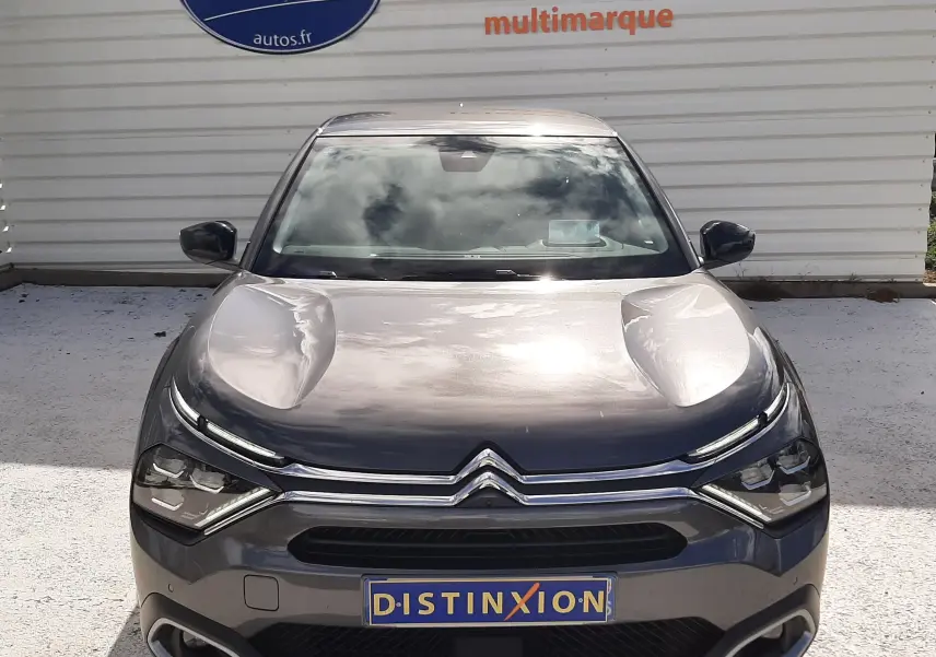 Vue de face d'une Citroën C4 gris métallisé 2024 avec calandre chromée et phares LED distinctifs.