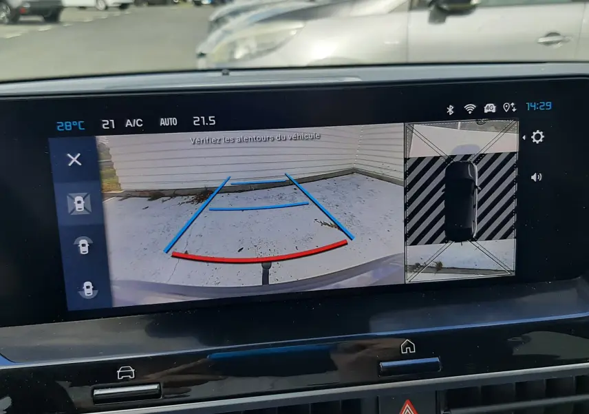 Écran intérieur de la Citroën C4 2024 montrant la caméra de recul avec lignes de guidage en bleu et rouge.