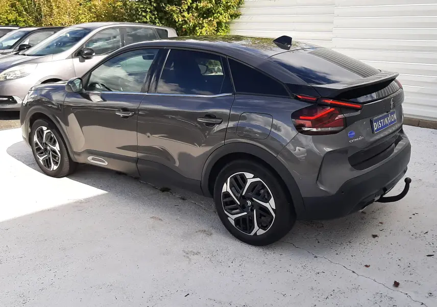 Vue 3/4 arrière droite d'une Citroën C4 gris métallisé 2024 avec feux LED et jantes bi-ton distinctives.