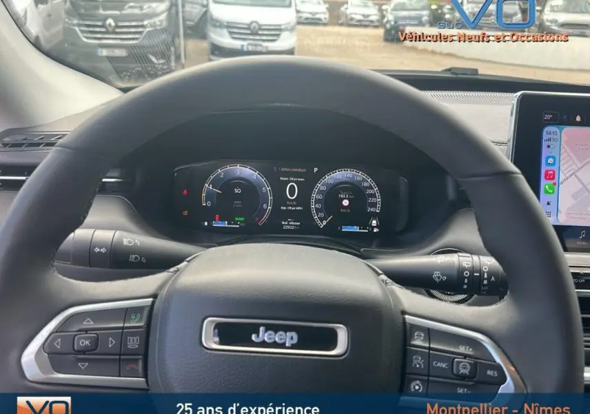 Vue intérieure centrée sur le volant Jeep Compass 2023 avec tableau de bord numérique et écran tactile visible à droite