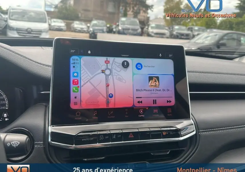 Vue intérieure centrée sur l'écran tactile du tableau de bord du Jeep Compass bleu 2023, avec commandes et affichage multimédia.