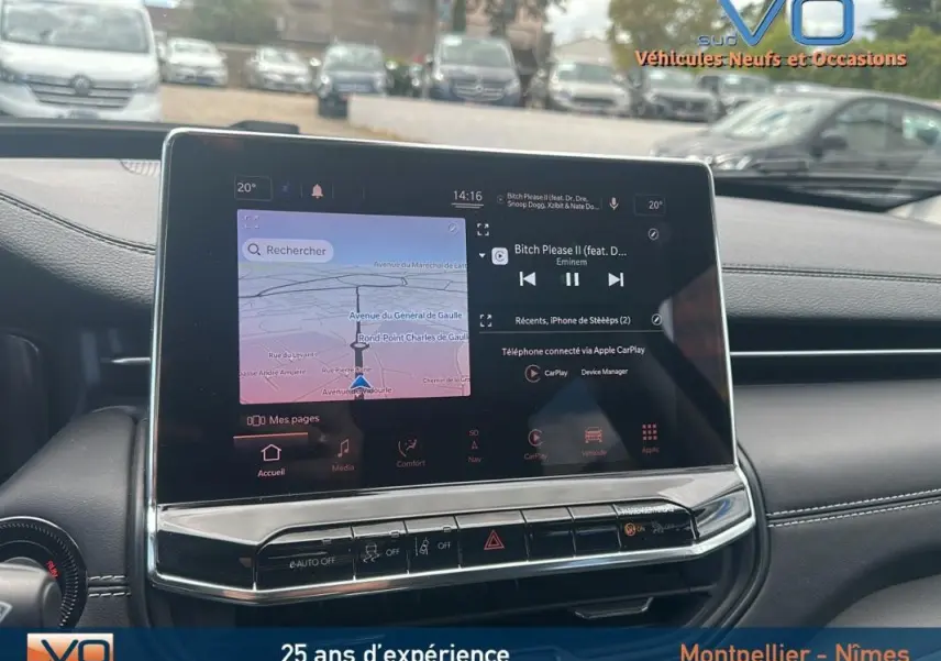 Écran tactile central du tableau de bord du Jeep Compass bleu 2023, avec navigation et musique affichées.