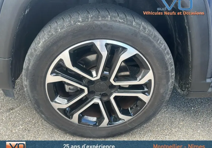 Gros plan sur la roue avant gauche du Jeep Compass bleu 2023 avec jante alliage 18 pouces au design moderne.