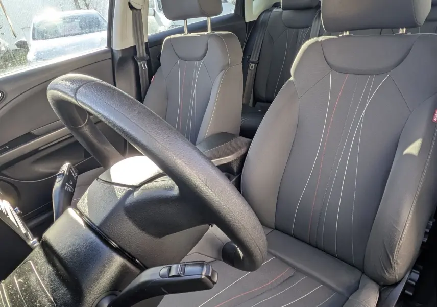 Vue intérieure avant droite du siège conducteur en tissu gris avec surpiqûres blanches et rouges du SEAT LEON II noir de 2013.