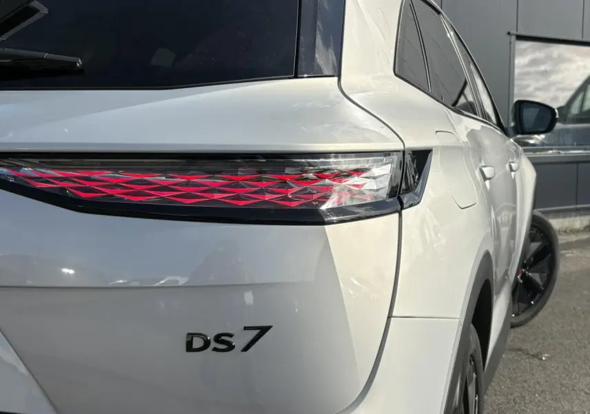 Vue 3/4 arrière droite du DS7 2024 Cristal Pearl avec feux arrière 3D et jantes alliage noires.
