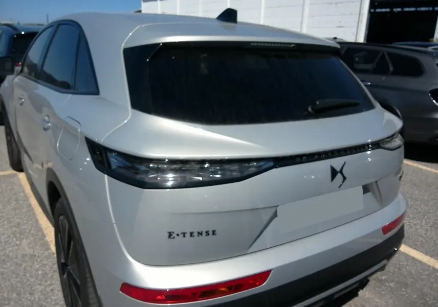 Vue 3/4 arrière du DS7 1.6 E-Tense 225 en Cristal Pearl avec feux arrière LED et logo DS distinctif.