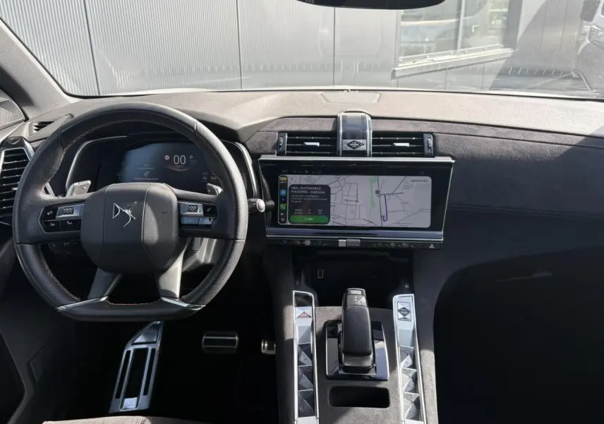 Vue intérieure avant du DS7 2024 avec tableau de bord et console en Alcantara noir profond et écran tactile central.