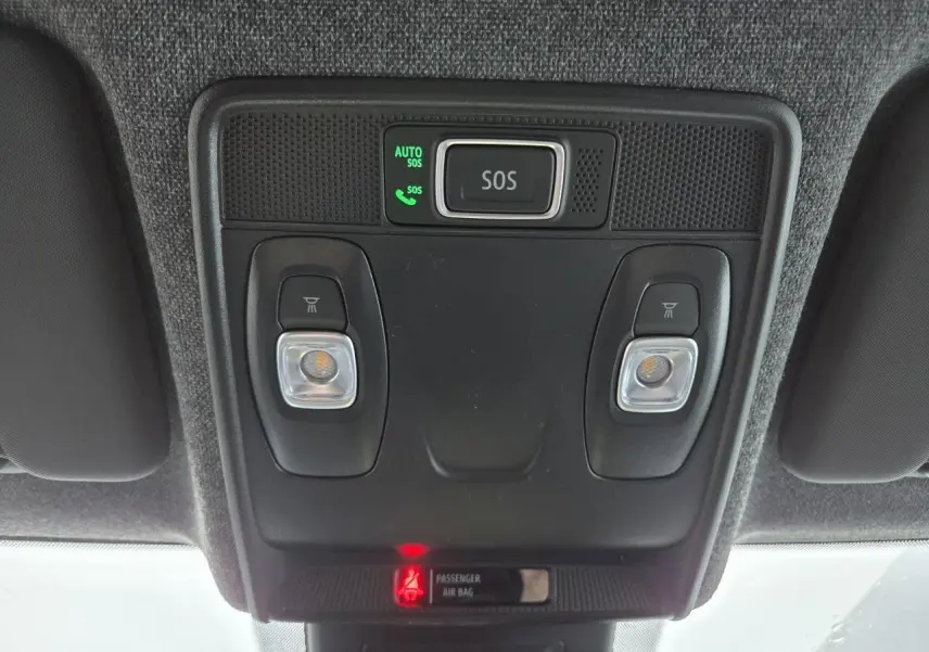 Vue en contre-plongée du panneau de plafonnier noir avec bouton SOS et éclairages de lecture dans un Renault Clio gris schiste.