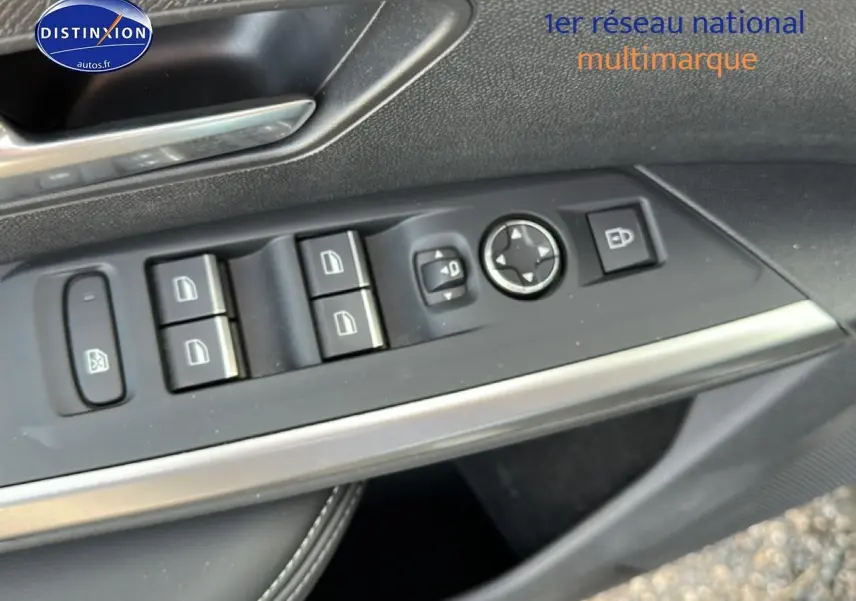 Vue rapprochée du panneau de commandes des vitres côté conducteur d’un Peugeot 3008 gris titane, avec boutons noirs et insert argenté.