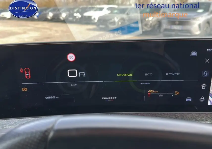 Tableau de bord numérique du Peugeot 3008 gris titane, affichage vitesse, charge et autonomie en vue frontale.