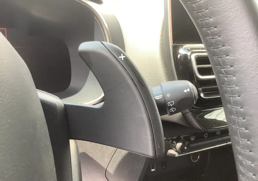 Gros plan sur la palette de changement de vitesse droite noire du volant du Citroën C5 Aircross Hybrid 2024, intérieur gris/noir.