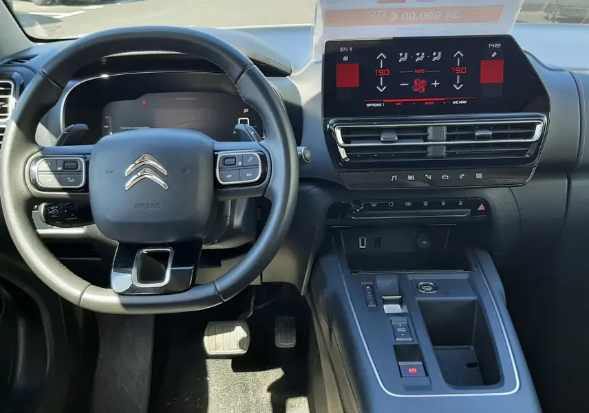 Vue intérieure avant du Citroën C5 Aircross Hybrid gris acier, tableau de bord avec écran tactile et volant multifonction.