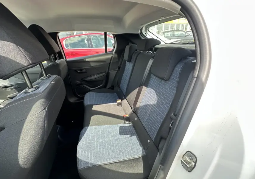 Vue intérieure arrière côté gauche de la Peugeot 208 blanche, montrant les sièges arrière en tissu bicolore gris et noir.
