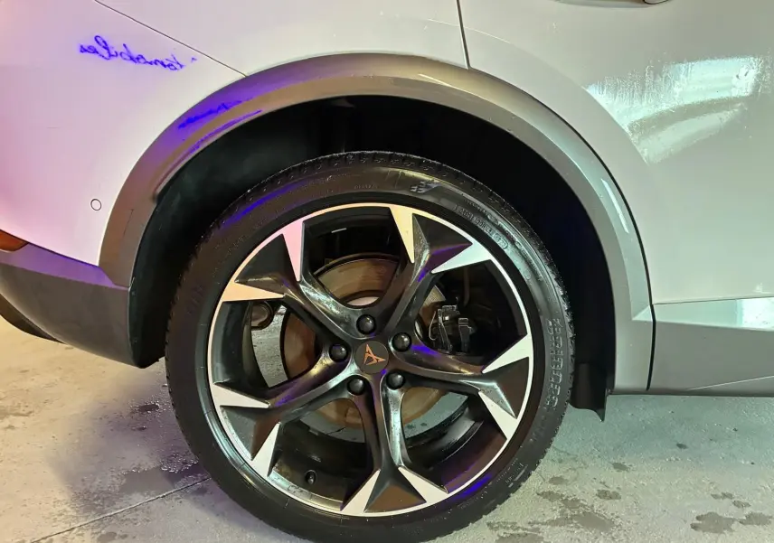 Gros plan sur la roue arrière droite du CUPRA Formentor gris 2024, mettant en valeur la jante alliage au design sportif.