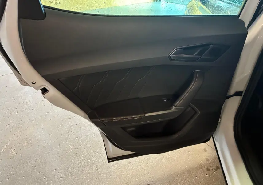 Vue intérieure de la porte arrière gauche noire avec surpiqûres contrastantes du CUPRA Formentor gris 2024.