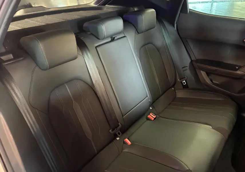 Vue intérieure arrière du CUPRA Formentor 1.4 E-HYBRID 245 DSG6 VZ 2024, sièges arrière noirs en tissu et cuir avec surpiqûres.