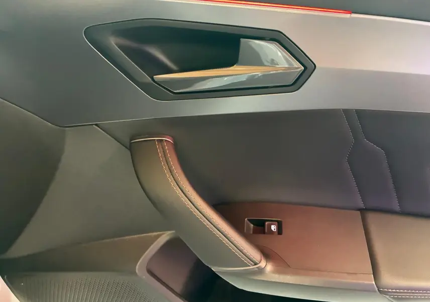 Détail de la poignée intérieure côté gauche en cuir noir avec surpiqûres sur la porte d’une CUPRA Formentor gris 2024.