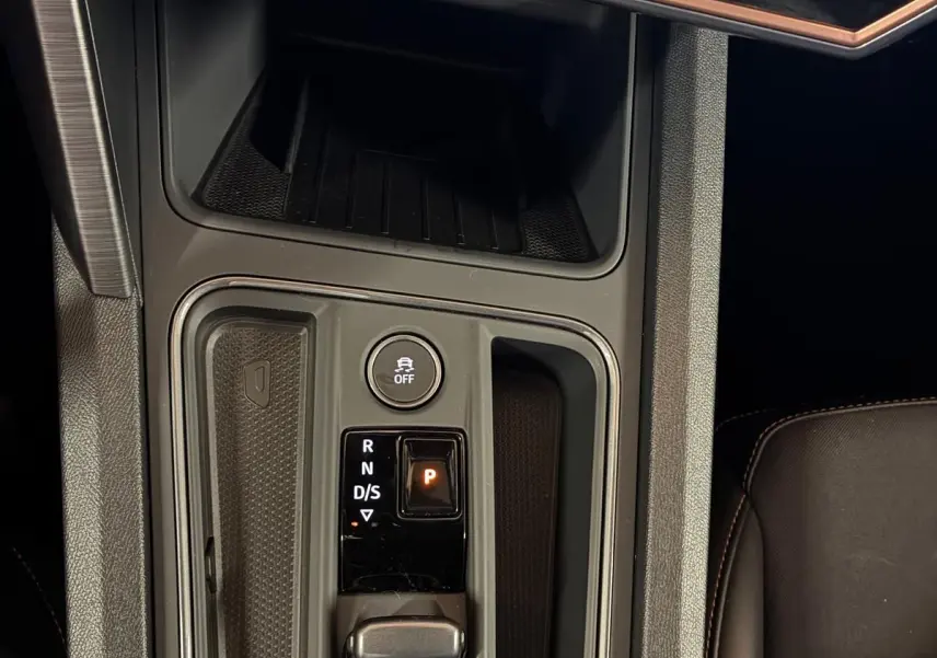 Vue plongeante sur la console centrale noire du CUPRA Formentor 1.4 E-HYBRID 2024 avec sélecteur de vitesse électronique et bouton de déverrouillage.
