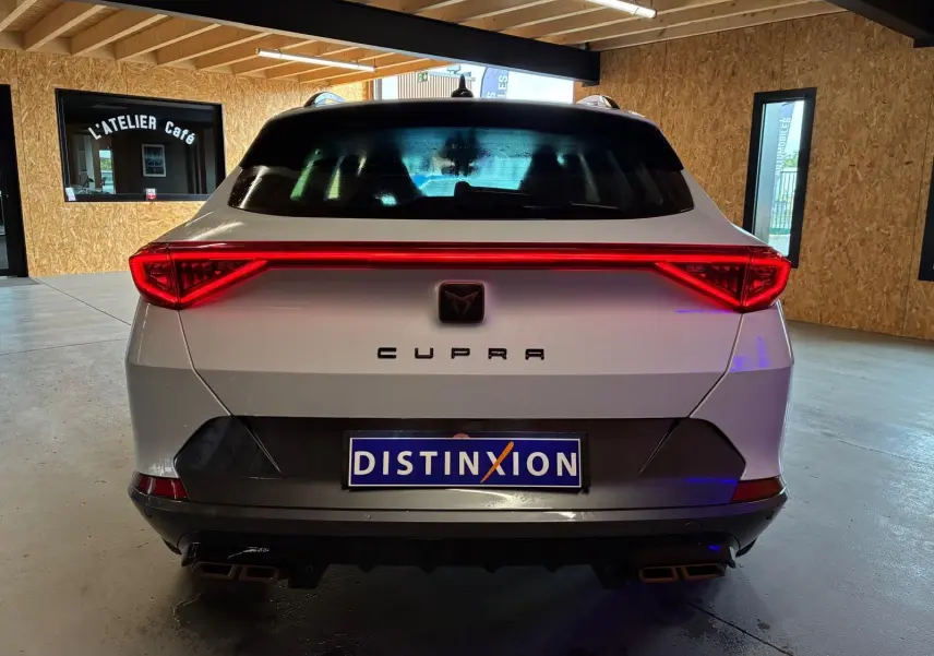 Vue arrière d’un CUPRA Formentor gris 2024 avec feux LED en bandeau et double sortie d’échappement carrée.
