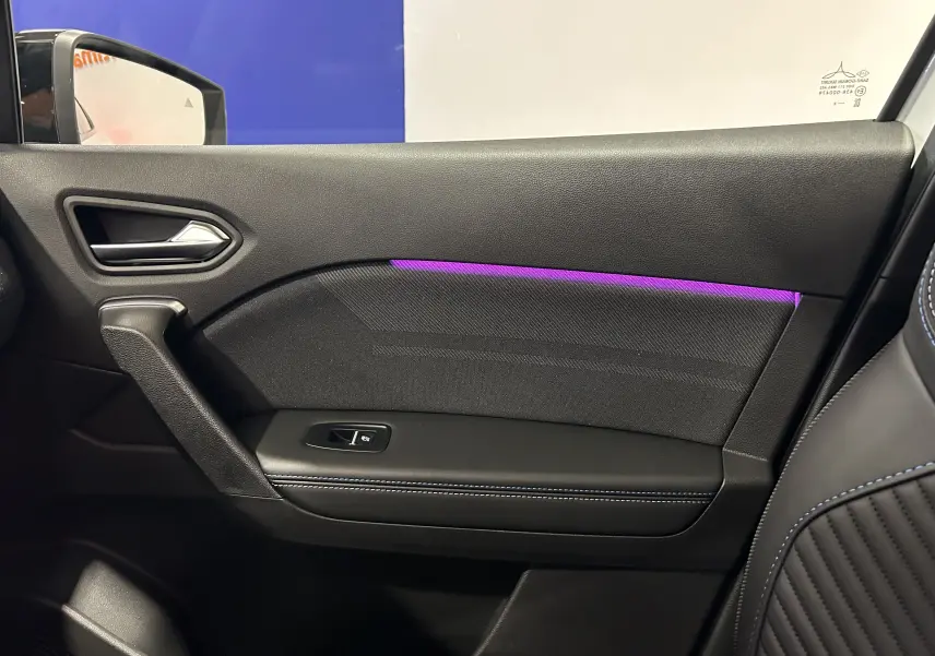 Vue intérieure côté gauche de la porte Renault Captur blanc nacré avec éclairage d'ambiance violet et surpiqûres bleues.