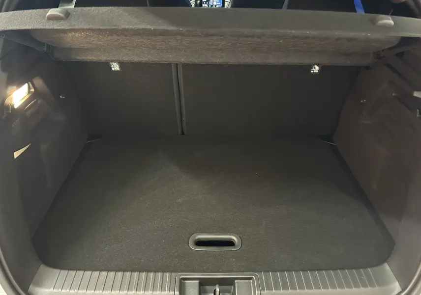 Coffre ouvert du Renault Captur blanc nacré, vue intérieure montrant l'espace de chargement vide et la tablette arrière.