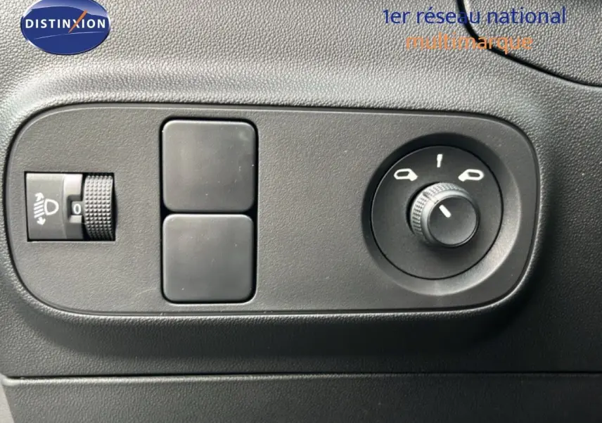 Détail des commandes de réglage des phares et des rétroviseurs dans l’habitacle d’une Citroën C3 gris Artense 2024.
