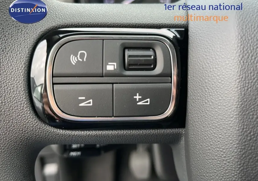 Gros plan sur les commandes de volume et téléphone intégrées au volant du Citroën C3 gris Artense métal 2024.