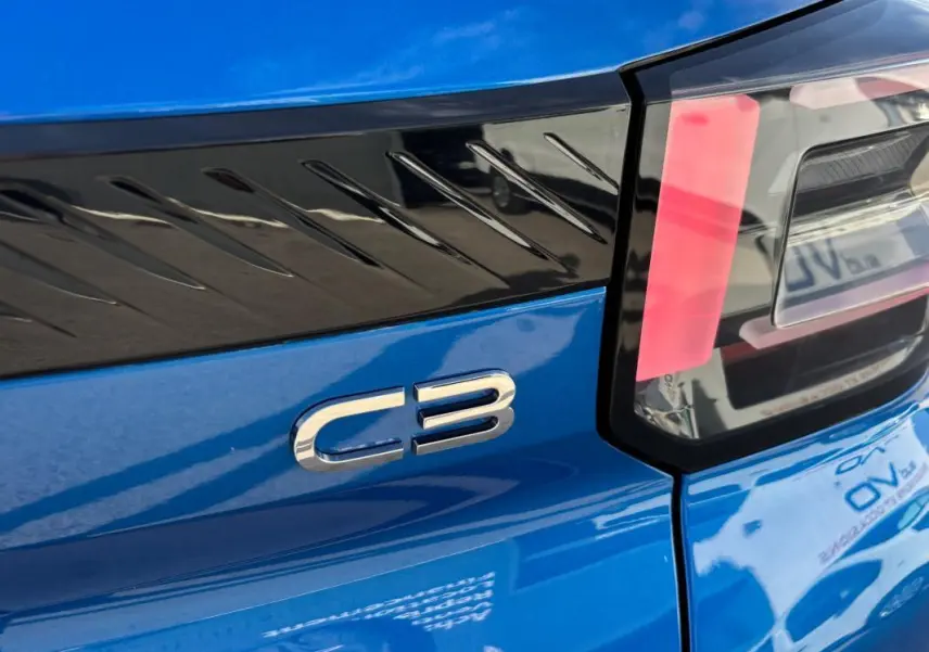 Gros plan sur l'arrière droit bleu vif du Citroën C3 2025, mettant en valeur le logo C3 et le feu arrière moderne.