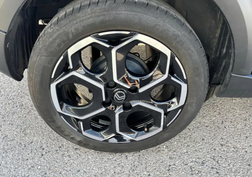 Gros plan sur la jante alliage 17 pouces noire et argentée de la Citroën C3 Turbo 100 ch, avec pneu monté.