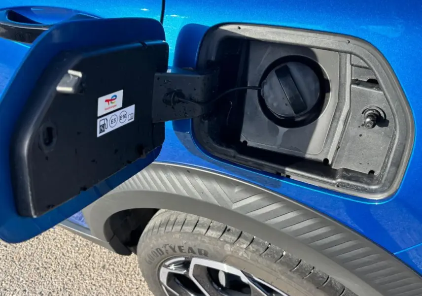 Gros plan sur la trappe à carburant ouverte côté gauche d’une Citroën C3 bleu 2025 avec jante alliage 17 pouces visible.