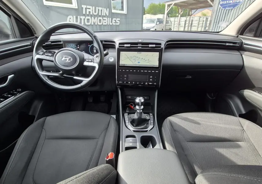 Vue intérieure avant du Hyundai Tucson 1.6 CRDI 136 Creative 2022, volant multifonction et console centrale avec boîte manuelle.