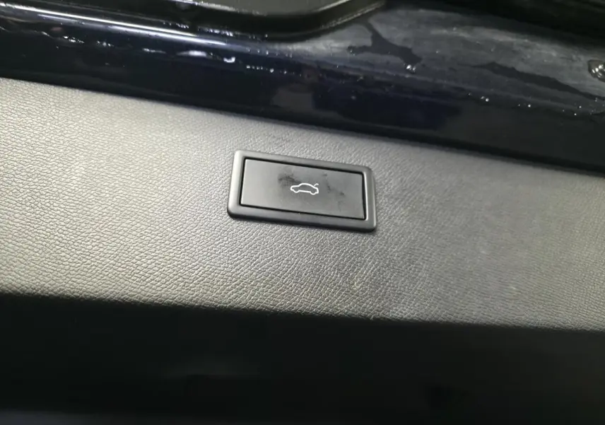 Bouton d'ouverture électrique du hayon sur la garniture intérieure d'un CUPRA Formentor bleu pétrole.