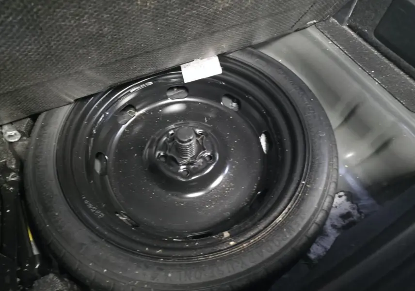 Gros plan sur la roue de secours noire dans le coffre d’un CUPRA Formentor bleu 2023.