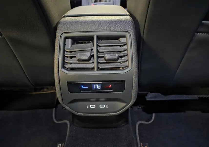Détail de la console arrière noire avec ventilation, réglage de climatisation à 17°C et deux ports USB-C éclairés.