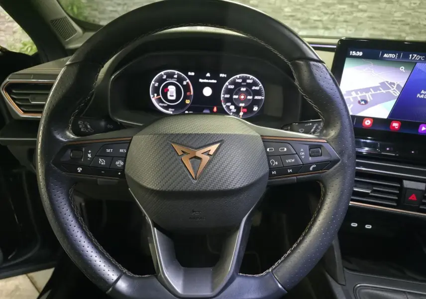 Vue rapprochée du volant sport en cuir noir avec logo CUPRA cuivre et tableau de bord digital du Formentor 2023.
