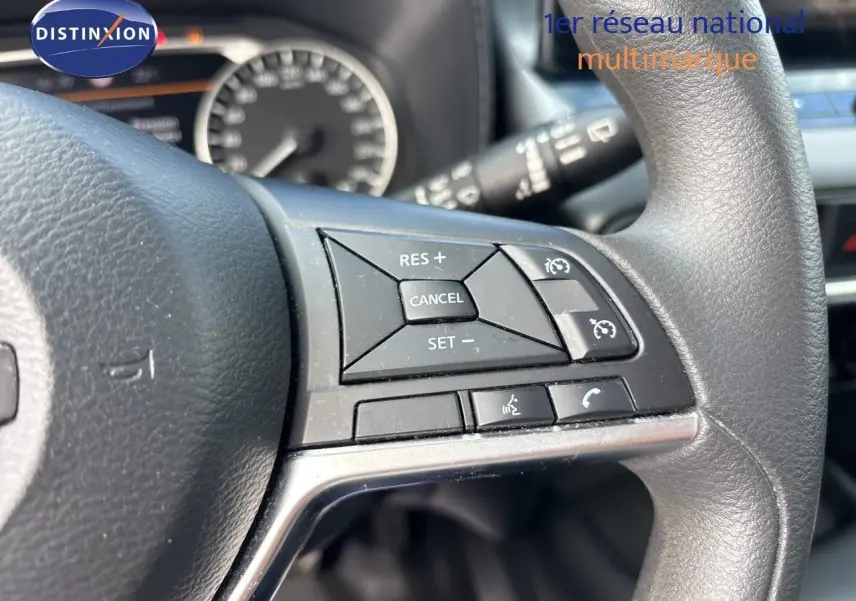 Gros plan sur les commandes au volant du Nissan Juke Hybrid 2025, avec boutons de régulateur de vitesse et téléphone.