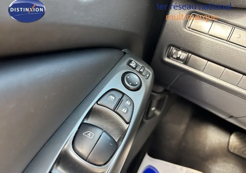 Gros plan sur les commandes de lève-vitres et rétroviseurs côté conducteur du Nissan Juke Hybrid 2025, intérieur noir.