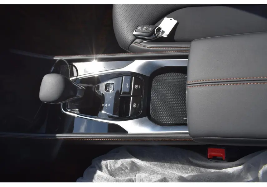 Vue plongeante sur la console centrale noire du MG Motor EHS 1.5 Hybrid+ 224 ch Luxury avec levier de vitesses et clé.