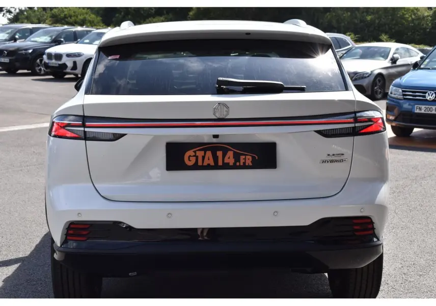 Vue arrière d'un MG Motor EHS blanc 2026, avec feux reliés par une bande rouge et badge Hybrid+ visible à droite.