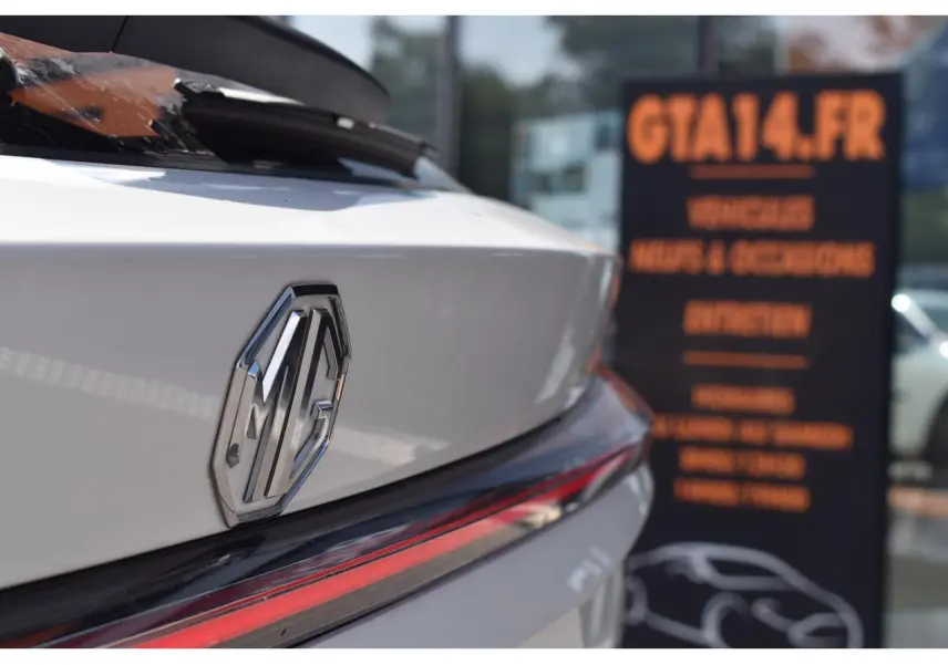 Gros plan sur l'arrière blanc du MG EHS 1.5 Hybrid+ 224 ch Luxury, avec le logo MG et un feu arrière allongé rouge.