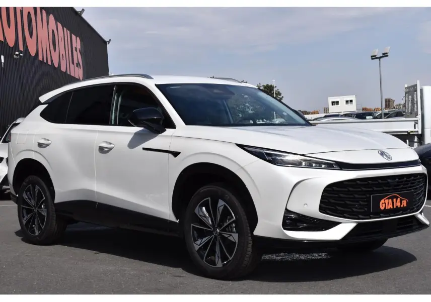 Vue 3/4 avant d’un MG MOTOR EHS blanc 2026, avec calandre noire large et jantes alliage bicolores distinctives.