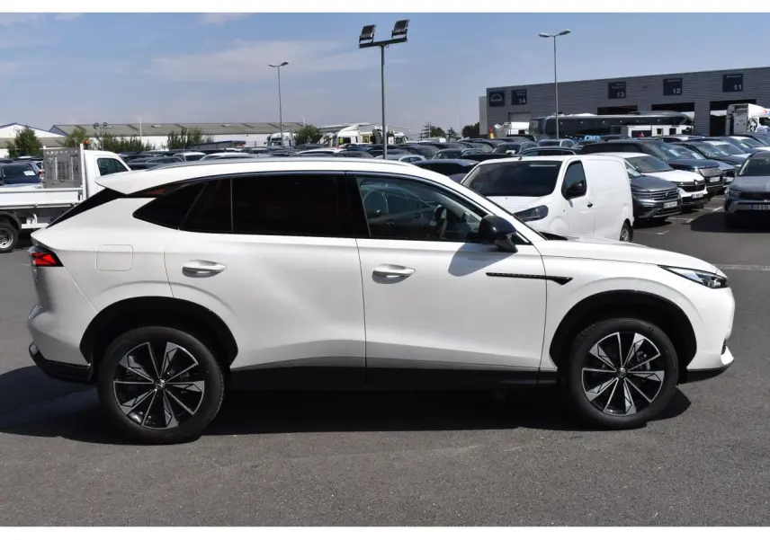 Vue de profil côté gauche du MG MOTOR EHS blanc 2026, SUV hybride avec jantes noires à motifs distinctifs.