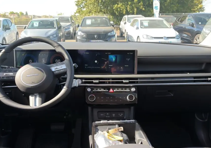 Vue intérieure avant du Hyundai Tucson 2026 gris ecotonic, avec tableau de bord numérique et volant multifonction cuir.