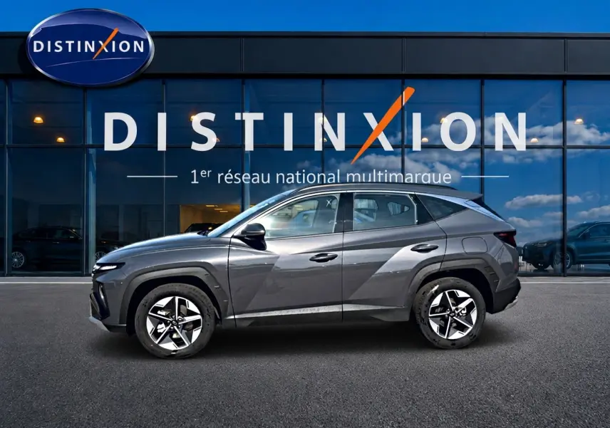 Vue de profil côté gauche d’un Hyundai Tucson gris ecotonic avec jantes alliage et lignes anguleuses marquées.