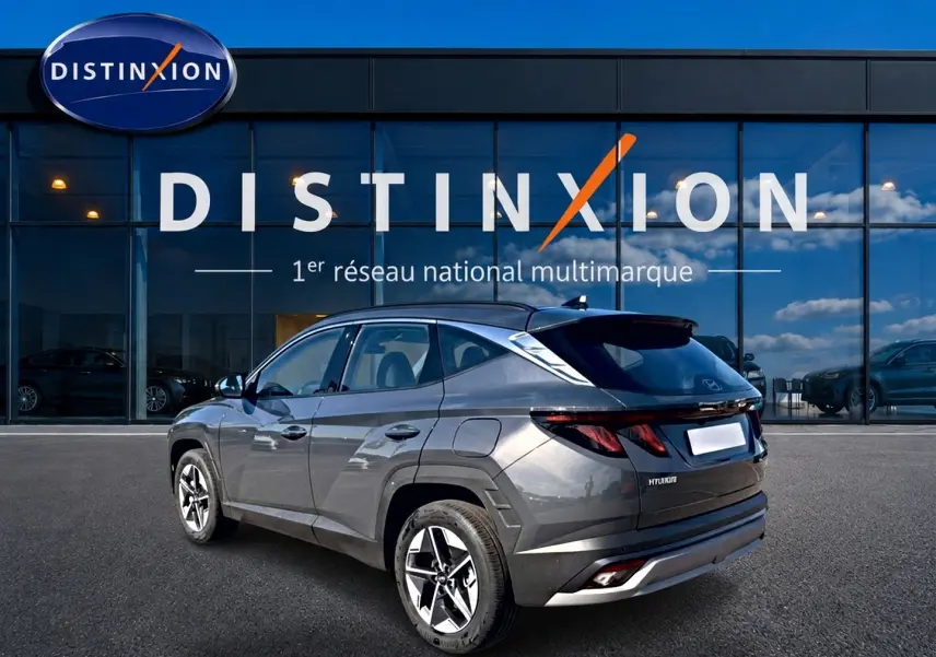 Hyundai Tucson gris écotonic vu en 3/4 arrière droit, avec jantes alu et feux arrière LED distinctifs.