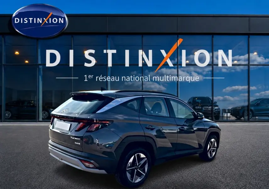Hyundai Tucson gris ecotonic en 3/4 arrière droit, avec jantes alu et feux arrière LED distinctifs.