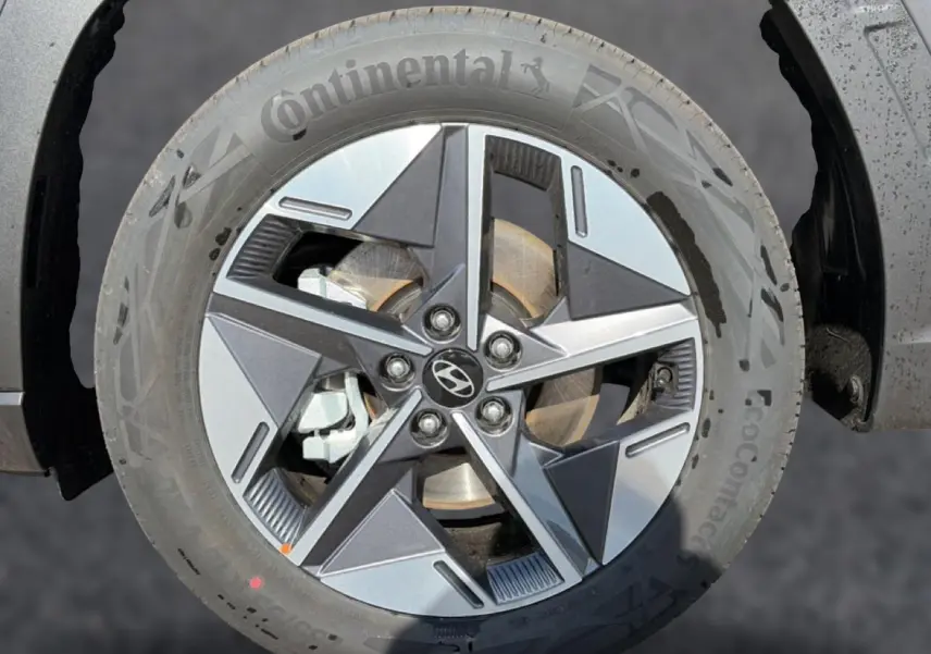 Gros plan sur la jante alu 18 pouces à cinq branches du Hyundai Tucson gris ecotonic, avec logo central Hyundai visible.